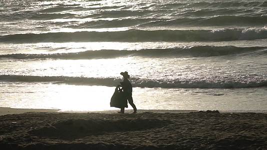 4K海边的老人拾荒老人海滩清洁工实拍视频视频的预览图