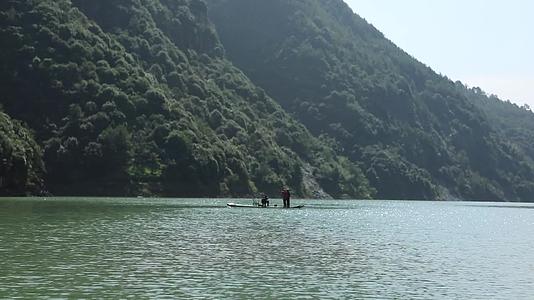 浙江温州泰顺县妇女在山水间划竹排视频的预览图