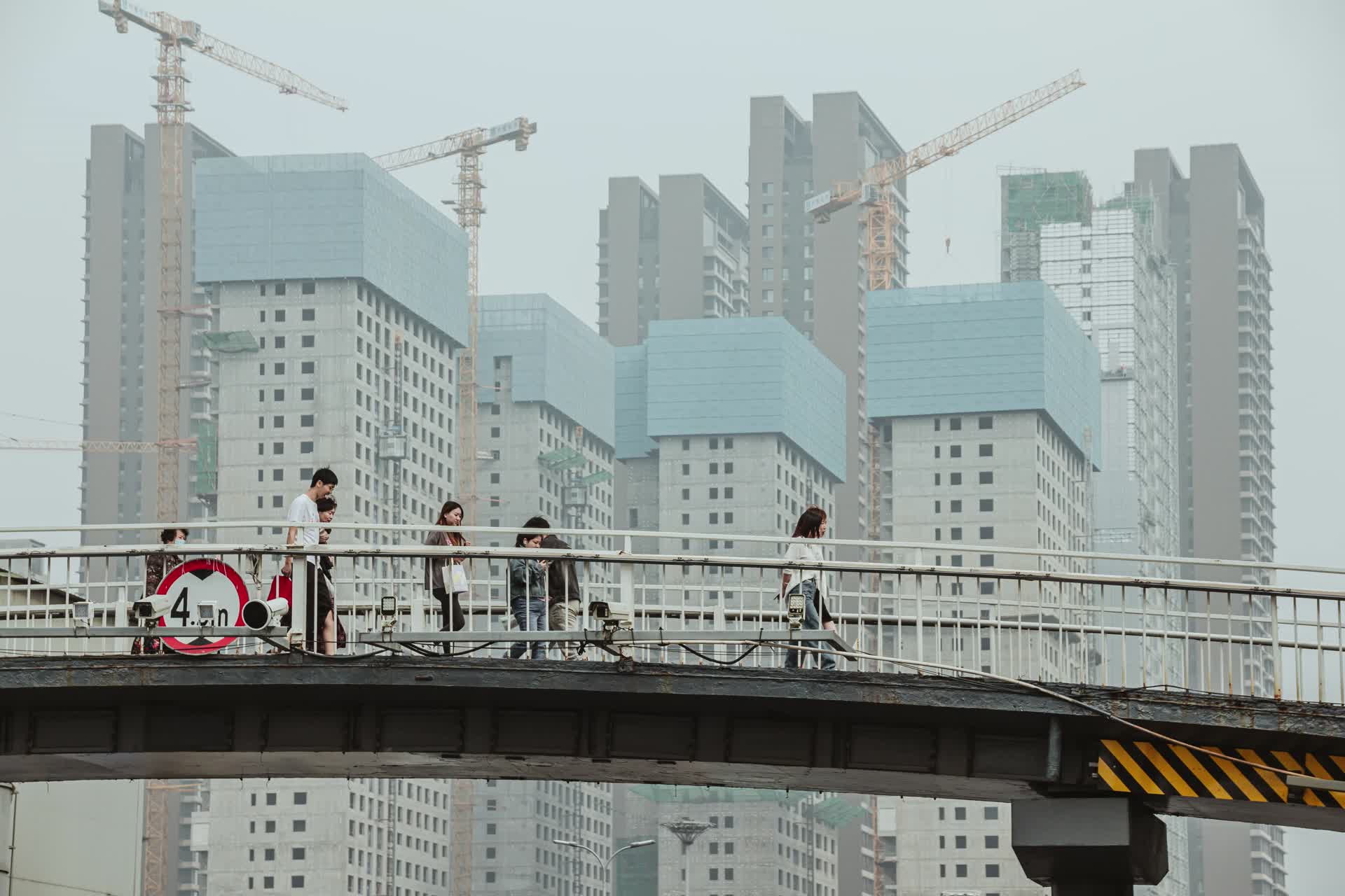 建筑工地高楼前行人过街天桥视频的预览图