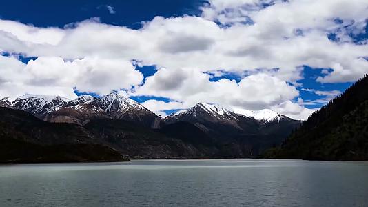 延时拍摄湖边雪山上的蓝天白云视频的预览图