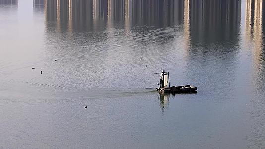 清晨一个渔民在海湾水面上撒网打鱼视频的预览图