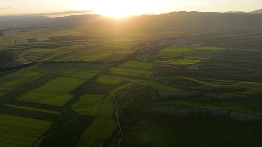草原耕地居民区群山日落霞光环绕风景视频的预览图