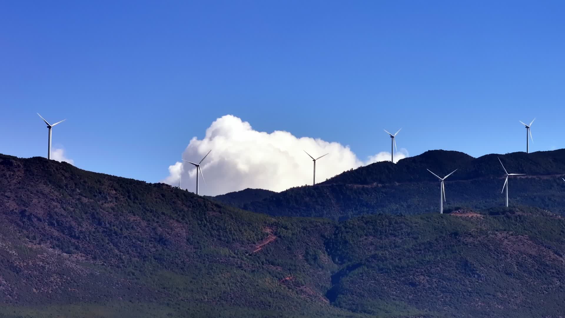 蓝天白云高山上的风力发电设施视频的预览图