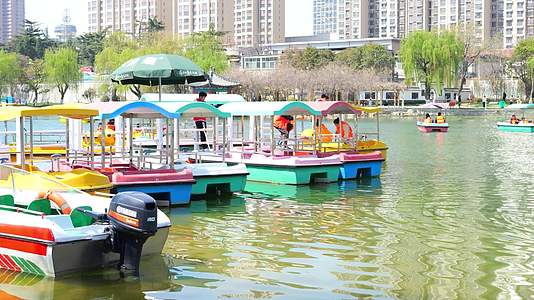 公园滕州荆河公园划船坐船休闲游玩春天人群周末散步视频的预览图