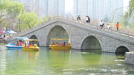 公园滕州荆河公园划船坐船休闲游玩春天人群周末散步视频的预览图