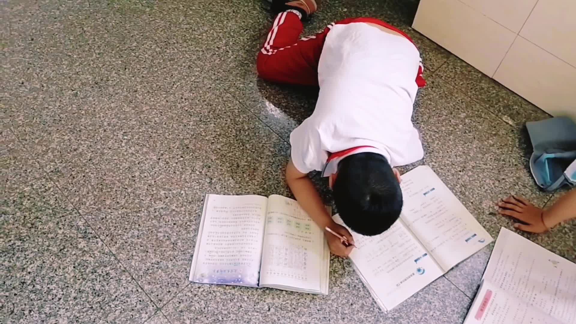 学生趴地上写作业视频的预览图