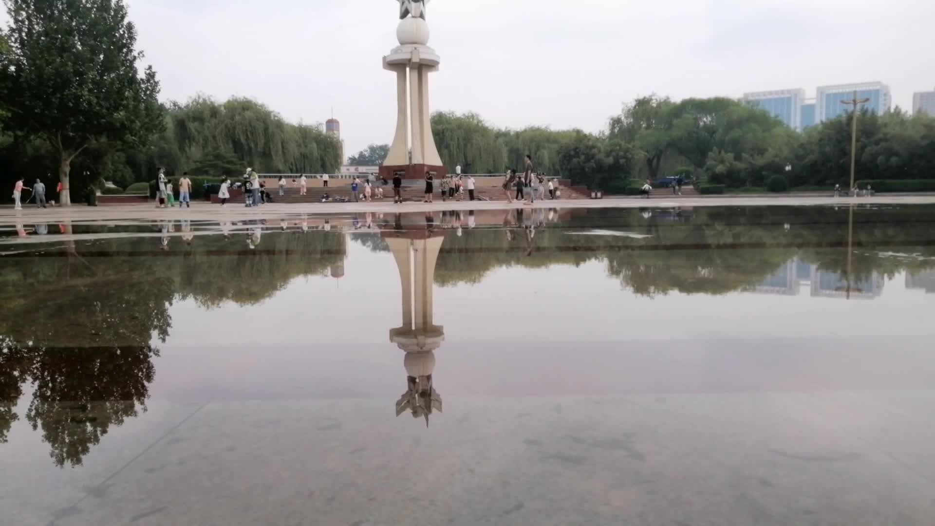 公园游人广场积水倒影视频的预览图