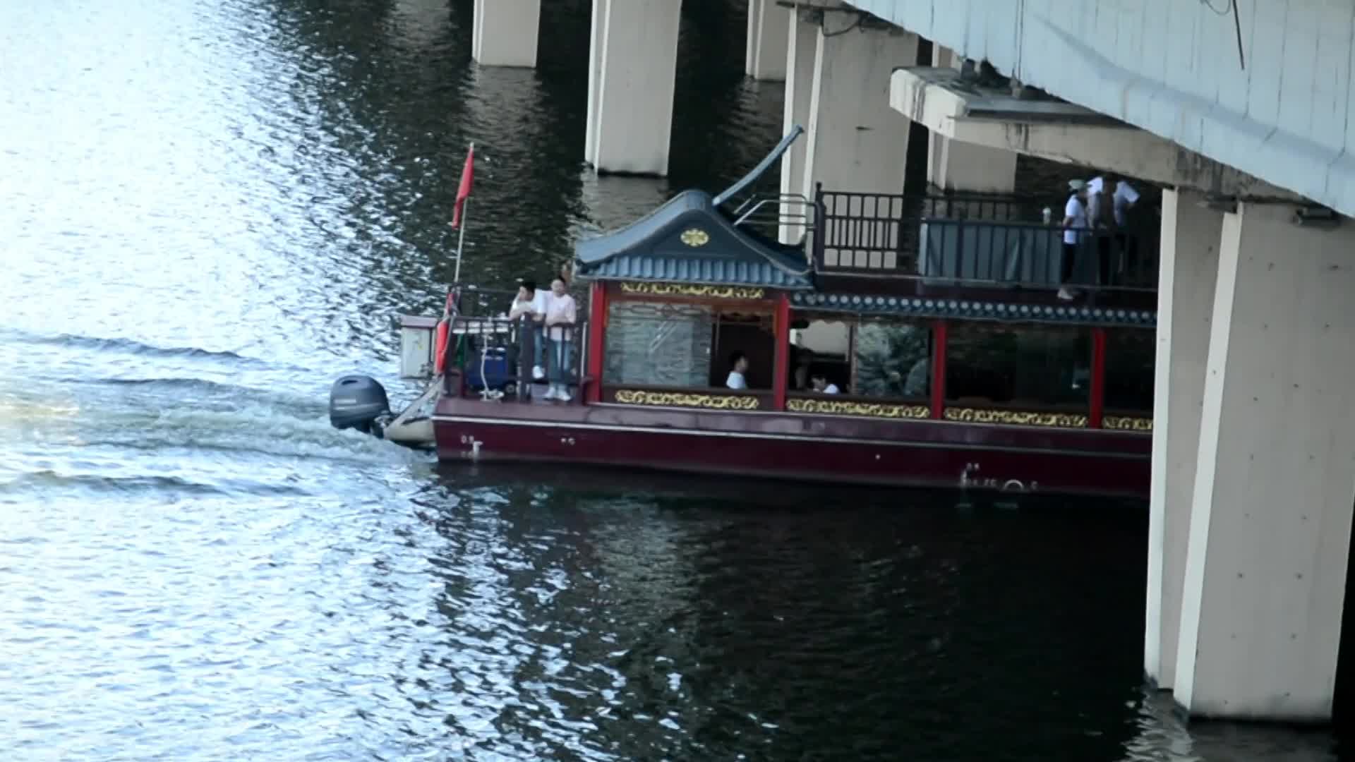 城市护城河中中国风游船穿桥而过视频的预览图