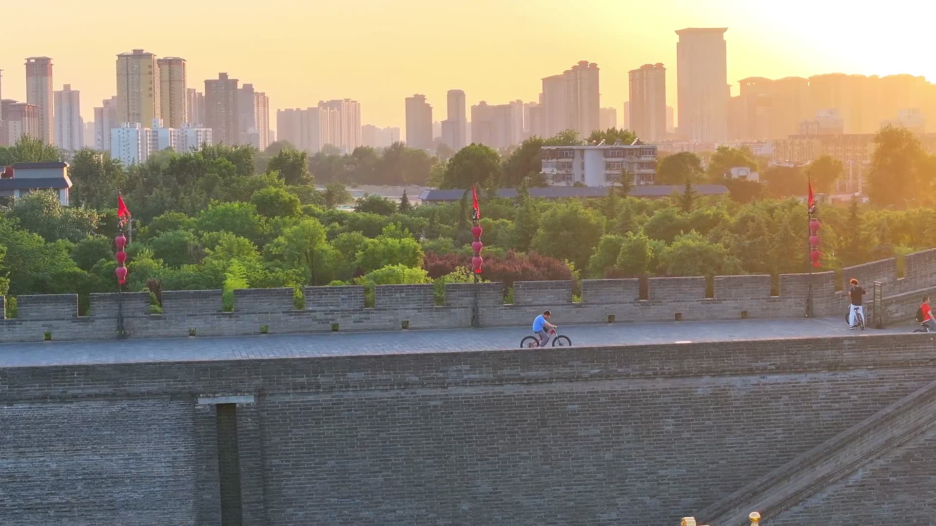 航拍陕西西安古城墙夕阳骑自行车视频的预览图